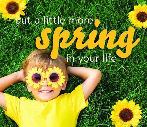 A boy with sunflowers over his eyes laying in the grass during spring